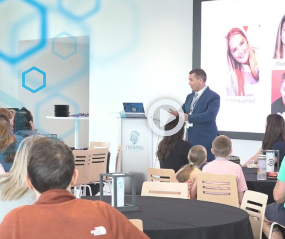 Screenshot of video captured at Tapper event with Dr. David De Jong speaking to a group of attendees with blue hexagons overlayed on the upper lefthand quadrant.